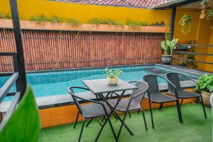 a table and chairs next to a swimming pool at Bali Bay By Urban Haven in Sanur