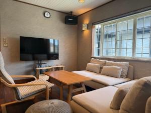 a living room with a couch and a tv at 伊勢神楽別邸 in Ise