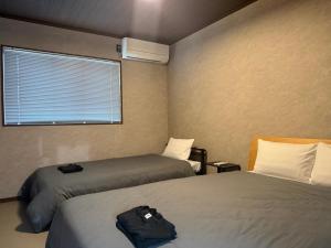 a hotel room with two beds and a window at 伊勢神楽別邸 in Ise