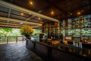 a bar in a restaurant with a counter with alcohol at Hanging Gardens of Bali in Payangan