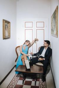 a woman in a blue dress sitting on a table with a man at Garden Palace Hotel in Castiglione del Lago