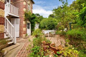 a patio with a table and some plants at Les Soliers in Étretat +32 photos