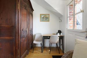 a room with a wooden door and a table and chairs at Les Soliers in Étretat