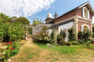 an old brick house with flowers in the yard at Les Soliers in Étretat
