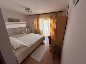 a small bedroom with a bed and a window at Lilac Apartments in Trogir