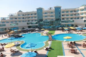 um hotel com uma grande piscina com mesas e guarda-sóis em The Guard Hotel em Cairo