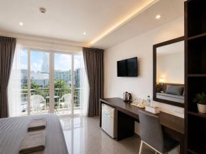 a hotel room with a desk and a large window at Doze Bangla in Patong Beach