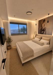 a bedroom with a large bed and a television at נווה ים סוף - מתחם דירות נופש פרימיום באילת in Eilat +33 photos