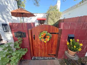 a wooden fence with a wreath on it at Casita Gundry- Boutique Hideaway, Quaint Historic Charm in Long Beach