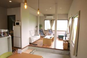 a living room with a couch and a refrigerator at The Glow Omachi B棟 in Omachi