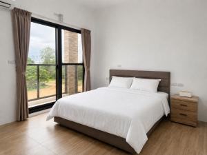 a bedroom with a large bed and a large window at Hai Jing Man Lu B&B in An-hsia +12 photos