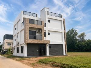 a tall white building on the side of a road at Hai Jing Man Lu B&B in An-hsia