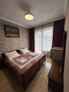 a bedroom with a large bed and a window at მყუდრო აპარტამენტი ანაკლიაში, Cozy Apartment in Anaklia in Zugdidi