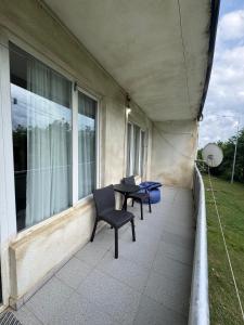 a balcony with two chairs and a table with a laptop at მყუდრო აპარტამენტი ანაკლიაში, Cozy Apartment in Anaklia in Zugdidi
