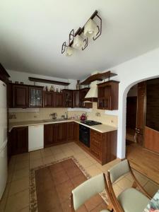 a large kitchen with wooden cabinets and a table at Wypoczynek pod leszczynami in Sitno