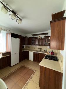 a kitchen with wooden cabinets and a white refrigerator at Wypoczynek pod leszczynami in Sitno