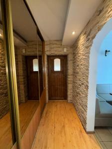 a hallway with a wooden door and a brick wall at Wypoczynek pod leszczynami in Sitno