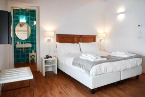 a bedroom with a large white bed and a mirror at Sopra Le Mura in Castellammare del Golfo