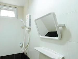 a white bathroom with a mirror and a sink at Cheaper Room in Surat Thani +52 photos