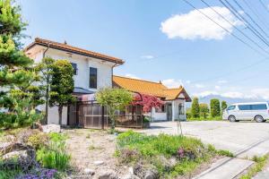 a house with a car parked in the driveway at The Glow Omachi B棟 in Omachi