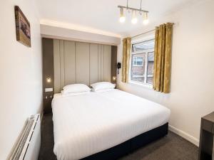 a bedroom with a large white bed and a window at OYO The Baltimore Hotel in Middlesbrough +91 photos