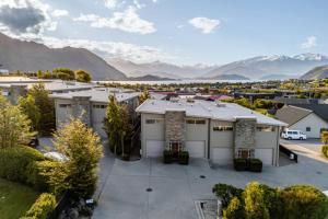 an aerial view of a house with mountains in the background at Resort-Style 2BR Alpine Apt | Pool, Spa & Garage in Wanaka