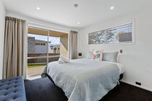a bedroom with a bed and a large window at Resort-Style 2BR Alpine Apt | Pool, Spa & Garage in Wanaka +20 photos