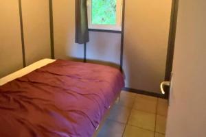 a room with a red bed in a room at Camping la Source in Thérondels +33 photos