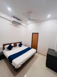 a bedroom with a large bed with blue pillows at Hotel Viny villa in Udaipur