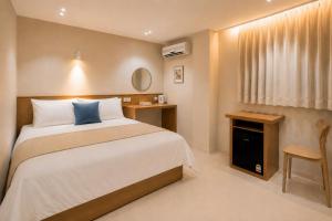 a bedroom with a bed and a table and a window at 부산 수영 블루닷 호텔 in Busan +30 photos