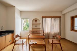a living room with two chairs and a table at Parthas Suites in Tiruchirappalli