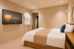 a hotel room with a bed and a flat screen tv at 부산 수영 블루닷 호텔 in Busan