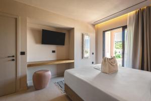 a hotel room with a bed with a bag on it at Palmea Suites in Pefki