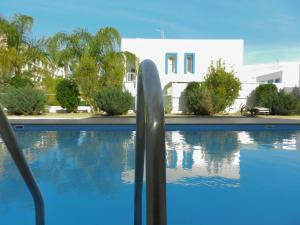 uma vista para uma piscina com um edifício branco em Konnos Flat em Protaras