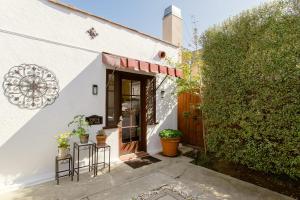 a white building with two stools in front of a door at Casita Gundry- Boutique Hideaway, Quaint Historic Charm in Long Beach +41 photos