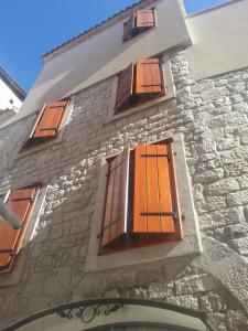 a stone building with wooden doors and windows at Villa Ruzica in Trogir