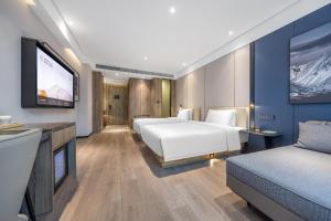 a hotel room with two beds and a flat screen tv at Atour Hotel Yancheng Gorvernment in Yancheng