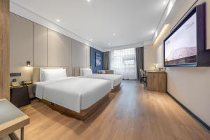 a hotel room with two beds and a projection screen at Atour Hotel Yancheng Gorvernment in Yancheng