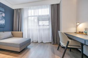 a living room with a desk and a couch and a table at Atour Hotel Yancheng Gorvernment in Yancheng