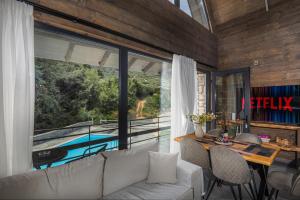 a living room with a table and a large window at LF Parnassos Chalet in Eptalofos