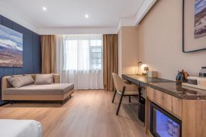 a living room with a couch and a table in a room at Atour Hotel Yancheng Gorvernment in Yancheng +8 photos