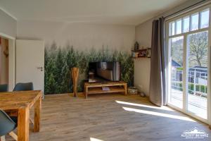 a living room with a tv and a table at Auszeit im Harz Haus 1 Wohnung Feuerstein in Schierke