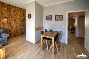 a dining room with a wooden table and chairs at Auszeit im Harz Haus 1 Wohnung Feuerstein in Schierke +9 photos