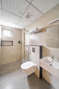 a bathroom with a toilet and a sink at Parthas Suites in Tiruchirappalli +17 photos