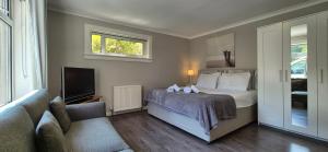a bedroom with a bed and a tv and a couch at Holyrood House in Edinburgh