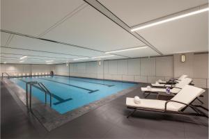 a large swimming pool with chairs in a building at Crowne Plaza Dalian Kerren in Dalian