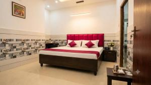 a bedroom with a large bed with a red headboard at Hotel HP Palace in Gorakhpur