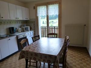 kuchnia ze stołem i krzesłami oraz kuchnia ze stołem i oknem w obiekcie Le Fayet d'en haut w mieście Abondance
