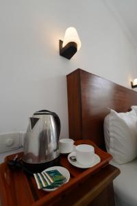 a coffee maker on a table next to a bed at Induwara Villa in Ahungalla