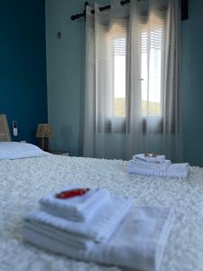 a bedroom with white towels on a bed with a window at Villa iliotropio in Lefokastro +72 photos